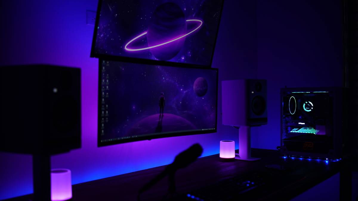 Gaming setup with surround sound speakers arranged in 5.1 configuration around a PC desk