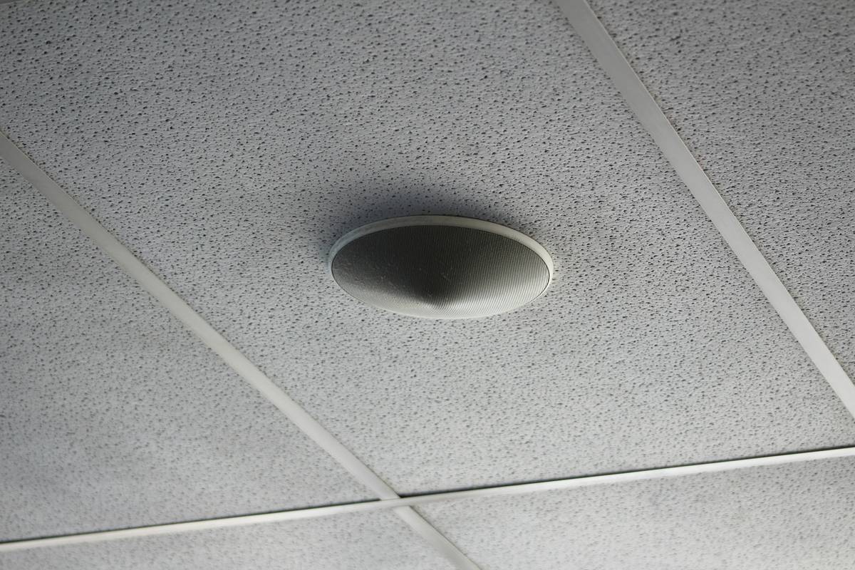Gamer using surround sound speakers ceiling setup for competitive advantage