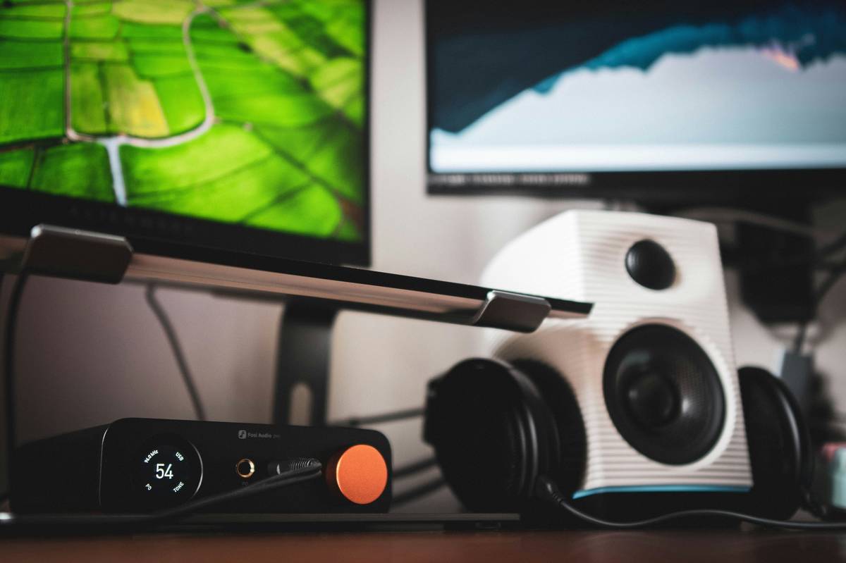 Optimal pc speaker system gaming desk setup with angled monitors and symmetrical speaker placement