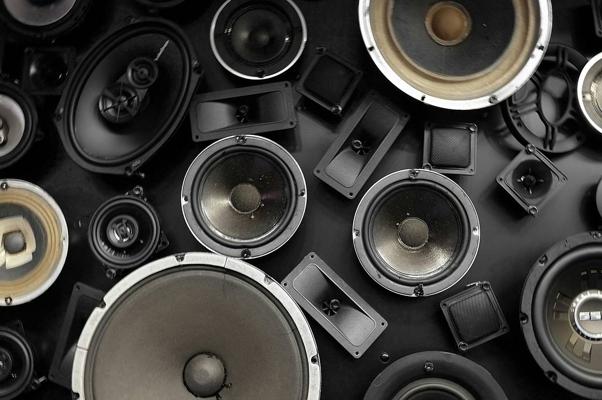 surround sound speakers stands holding gaming PC speakers at ear level on a hardwood floor